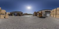 a sphere shot taken looking at boxes and boxes behind a fence in front of the warehouse