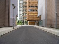 this is an empty street in the middle of some buildings, and a lamp post