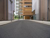 this is an empty street in the middle of some buildings, and a lamp post