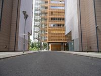 this is an empty street in the middle of some buildings, and a lamp post