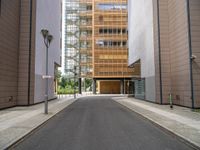 this is an empty street in the middle of some buildings, and a lamp post