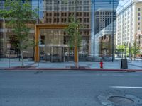 an empty street with buildings and parked cars on the sidewalks and green lanes on the sidewalk