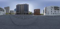 this photo depicts an empty street with multiple buildings and a park bench in front of them