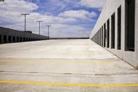 empty parking lot with empty signs on the side of it in daytime light clouds can be seen behind the building