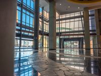 large lobby with tiled floor and windows with large glass wall on the side of it