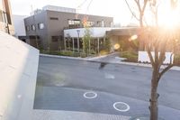 a couple of buildings with a tree and an umbrella outside of it in the sunlight