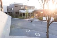 a couple of buildings with a tree and an umbrella outside of it in the sunlight