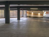 an empty parking garage with wooden railings on the walls and a door to an outside walkway