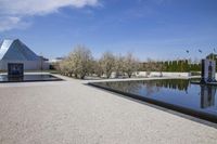an outdoor pool with stairs leading to a building with a pyramid and a triangle shaped structure