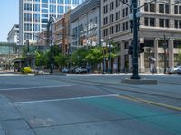 an empty street with buildings and parked cars on the sidewalks and green lanes on the sidewalk