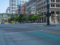 an empty street with buildings and parked cars on the sidewalks and green lanes on the sidewalk