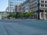 an empty street with buildings and parked cars on the sidewalks and green lanes on the sidewalk