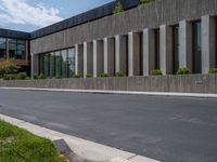 a building with a logo painted on the side near a street that has a sidewalk next to it