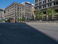 an empty street with buildings and parked cars on the sidewalks and green lanes on the sidewalk