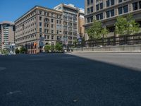 an empty street with buildings and parked cars on the sidewalks and green lanes on the sidewalk