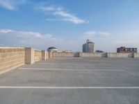 several large empty parking spaces in the city with buildings nearby in front of them -