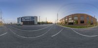 the view of an intersection from the side of a street in front of a brown building