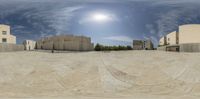 there is a ball being used as a 360 - view camera in this image there are buildings and a skateboard ramp behind them