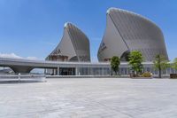 a large, modern building with a curved roof and two different shaped windows on one side