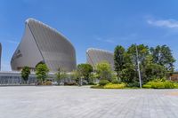 a large, modern building with a curved roof and two different shaped windows on one side