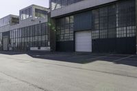 a city side view with an industrial building and an empty street in the foreground