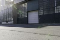 a city side view with an industrial building and an empty street in the foreground