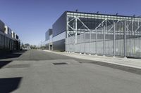 a parking lot with concrete floor and large glass building in the back ground on a clear day