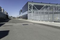 a parking lot with concrete floor and large glass building in the back ground on a clear day