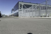 a parking lot with concrete floor and large glass building in the back ground on a clear day