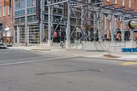 a building with a fence near the side of it on the street corner of the city