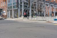 a building with a fence near the side of it on the street corner of the city