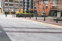 a parking lot has benches and tables in it, and a red brick building in the background