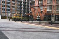 a parking lot has benches and tables in it, and a red brick building in the background