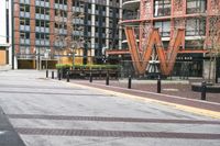 a parking lot has benches and tables in it, and a red brick building in the background