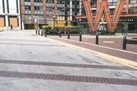 a parking lot has benches and tables in it, and a red brick building in the background