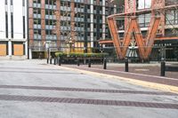 a parking lot has benches and tables in it, and a red brick building in the background