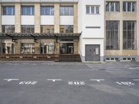 an empty building with signs on the street and people on bikes in traffic passing by