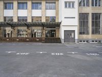 an empty building with signs on the street and people on bikes in traffic passing by