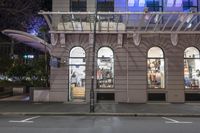 the corner of an empty building has windows lit with brightly lit lights on it's side