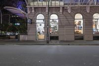 the corner of an empty building has windows lit with brightly lit lights on it's side