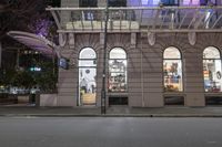 the corner of an empty building has windows lit with brightly lit lights on it's side