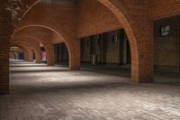 a brick walkway is seen between two archways to create an open space for a couple of people