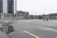 the empty parking lot has only snow on the ground in front of an old brick factory