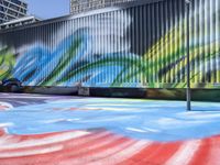 a colorful skate park with a person jumping up high in the air on the ground