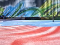 a colorful skate park with a person jumping up high in the air on the ground