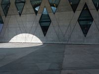 a shadow of a man walking with his back towards the camera of the building as it is lit by the light