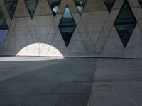 a shadow of a man walking with his back towards the camera of the building as it is lit by the light