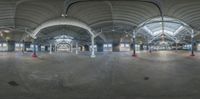 a picture of a huge empty room with fire hydrants and ceiling high up in view