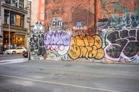 a wall with graffiti has been vandalized in the city corner of a street