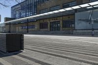 a black box sitting on a city street near a building and trees in front of it